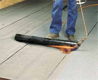 Hold brænderen foran rullen, så flammen både varmer bagsiden af rullen og oversiden af underlaget.