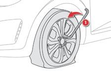 Praktiske informationer Afmontering af hjul F Fjern mærkaten, der sidder midt i nødhjulet (fortæller at et hjul skal repareres), og lim den på i kabinen i førerens synsfelt.