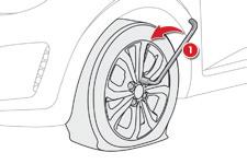 Problemløsning Afmontering af hjul F Fjern mærkaten, der sidder midt i nødhjulet (fortæller at et hjul skal repareres), og lim den på i kabinen i førerens synsfelt.