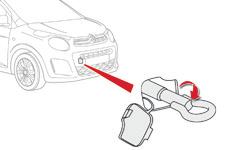 Problemløsning Bugsering af bilen Bilen kan kun bugseres foran. F Tag den aftagelige bugserkrog, der opbevares i værktøjskassen, under måtten i bagagerummet.